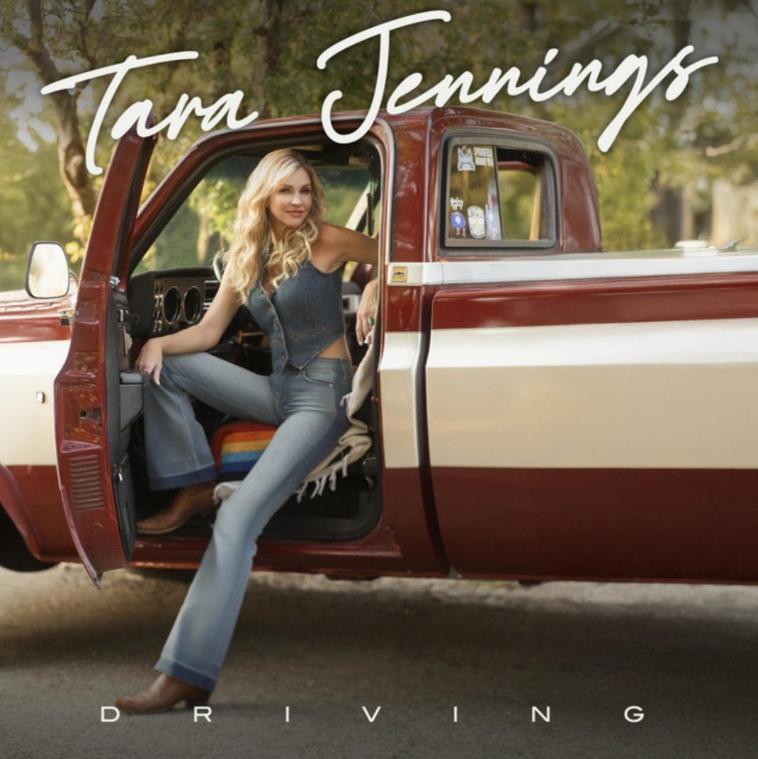Tara Jennings standing in the open door of a vintage red and white pickup truck, smiling, wearing a denim vest, flared jeans, and brown cowboy boots. Text reads "Tara Jennings" and "Driving" — album cover art.